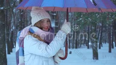 女孩站在伞下扭动它，在雪地上倾泻